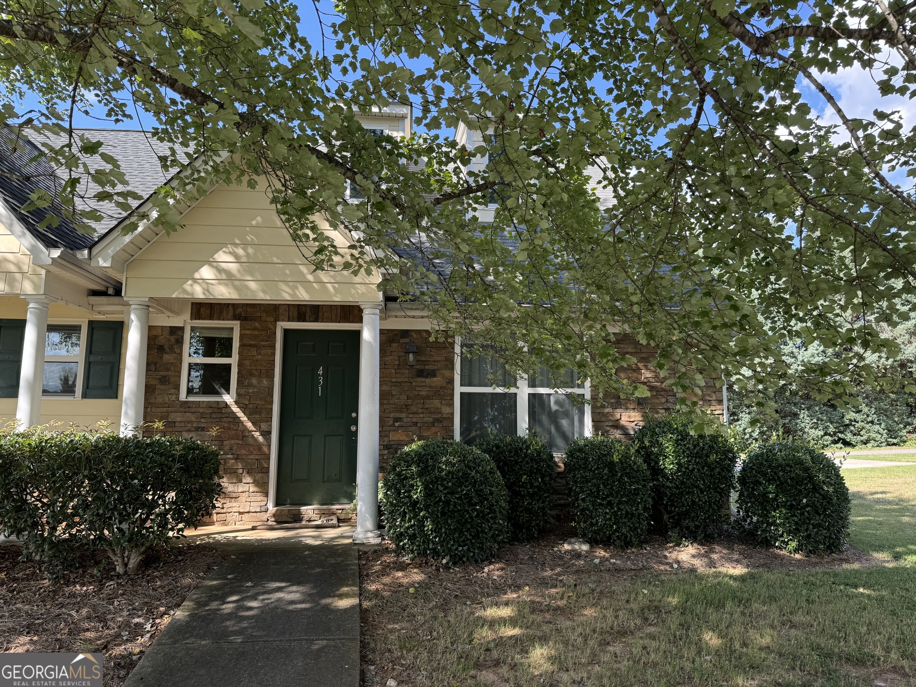 front view of a house with a tree in a yard