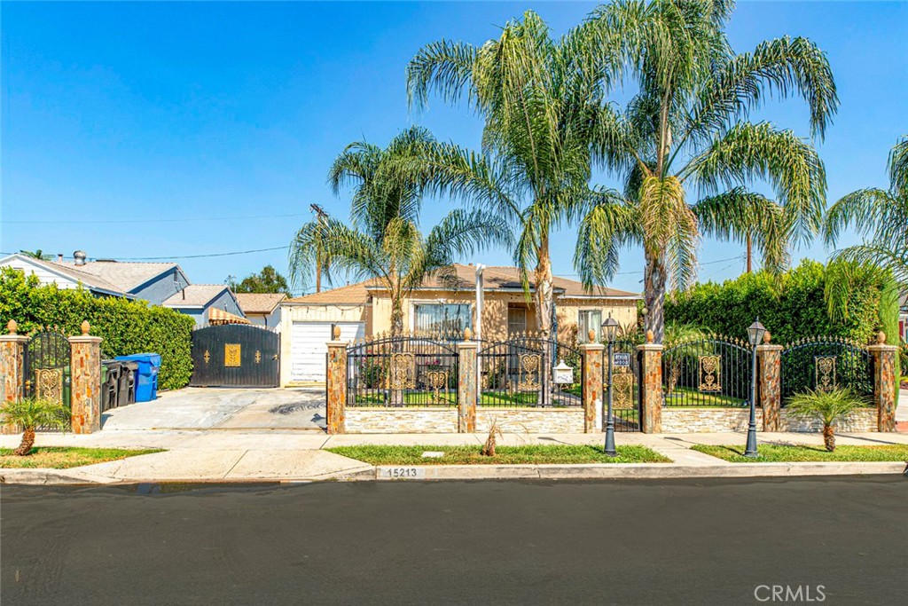 a view of a house with a yard and palm trees