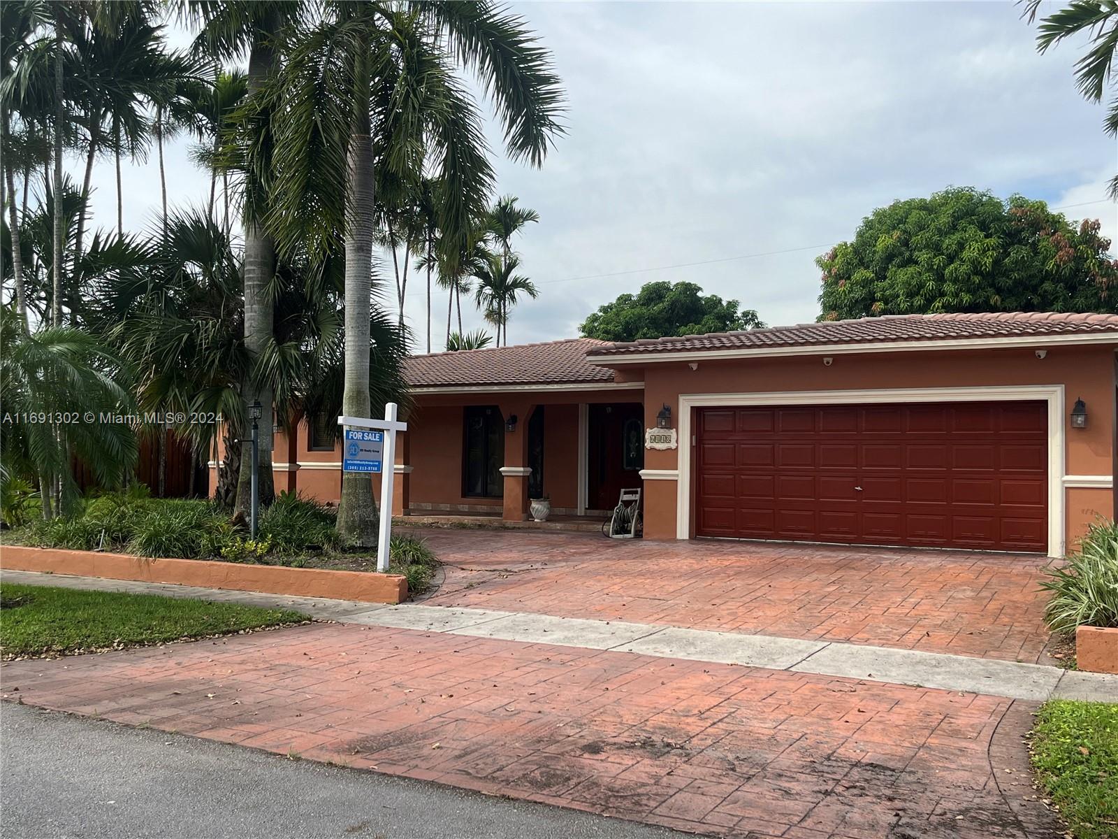 a view of a house with a yard and palm trees