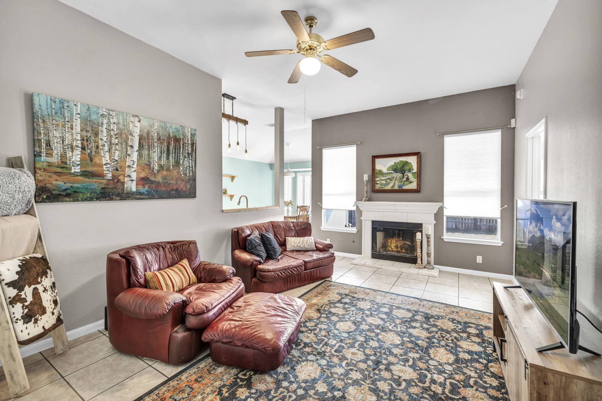 a living room with furniture a flat screen tv and a fireplace