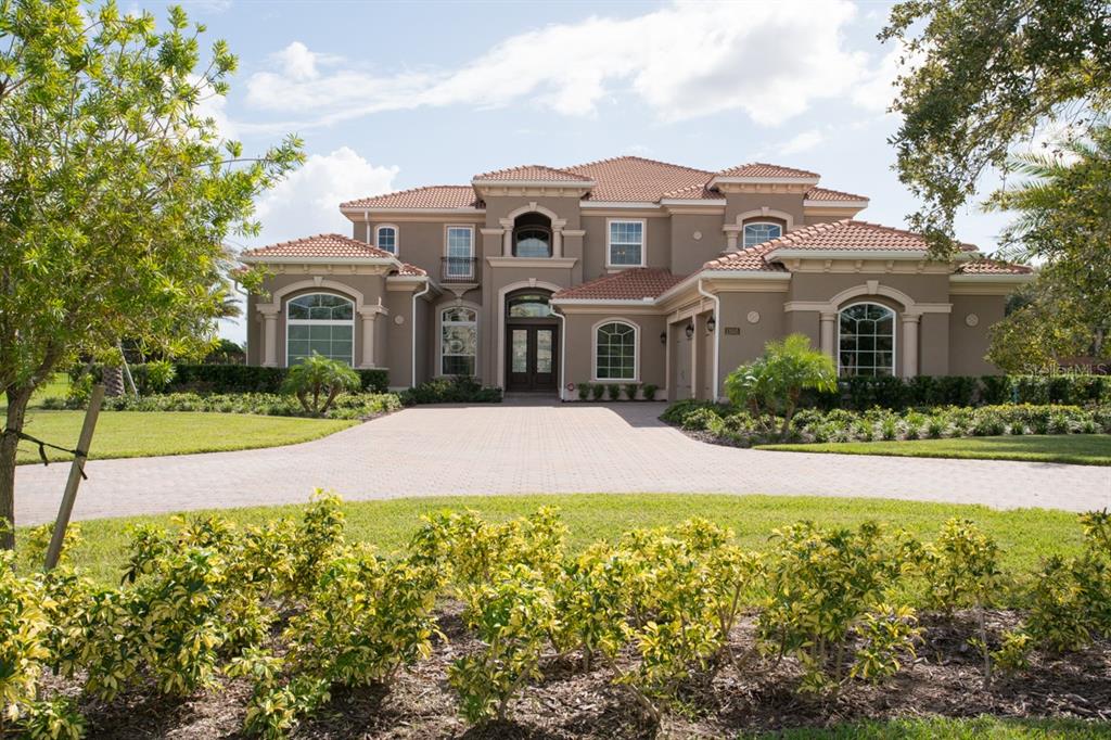 a front view of a house with yard and green space