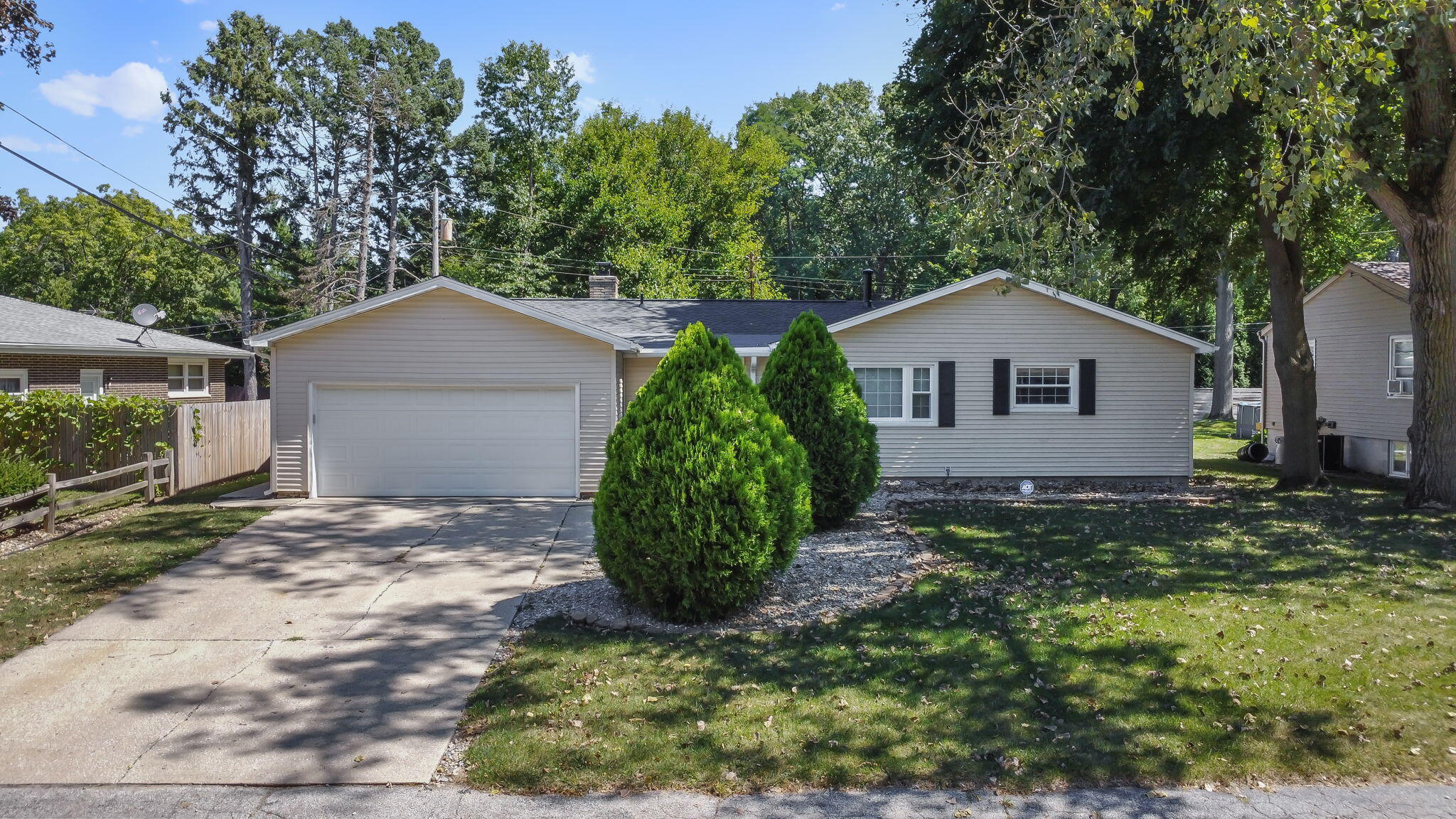 a view of a house with a yard and large tree