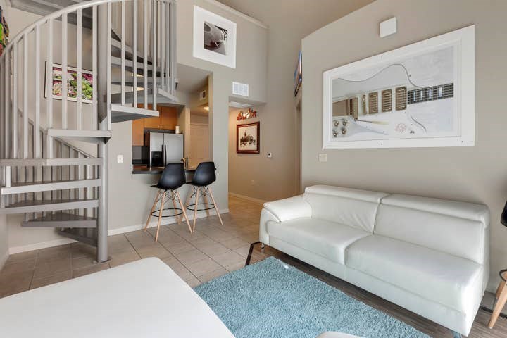 a living room with furniture a rug and white walls