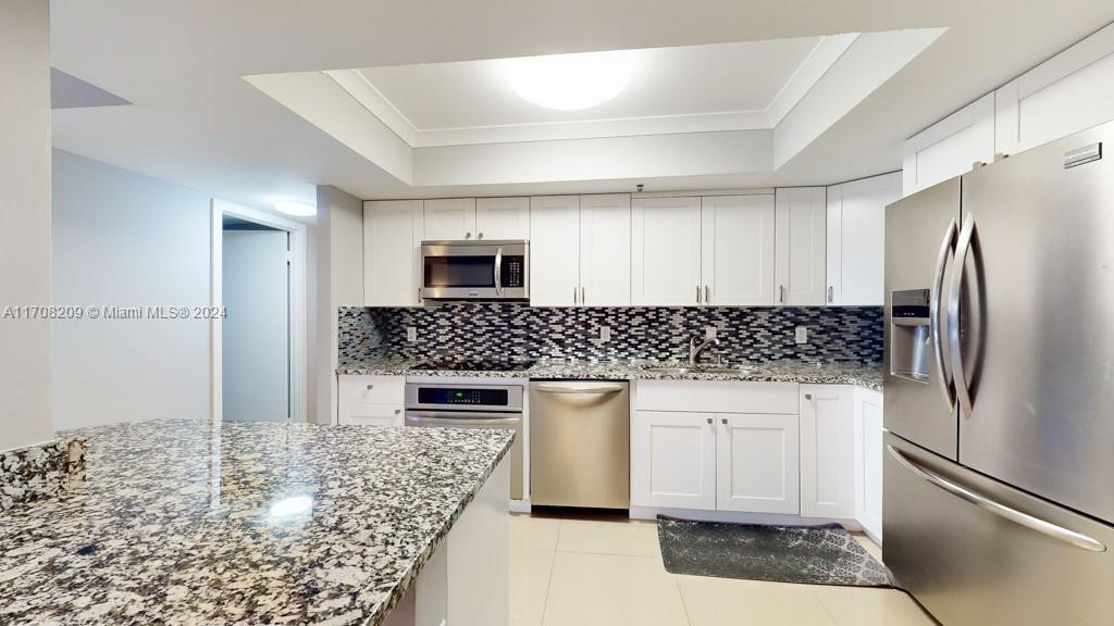 a kitchen with stainless steel appliances granite countertop a refrigerator and a stove