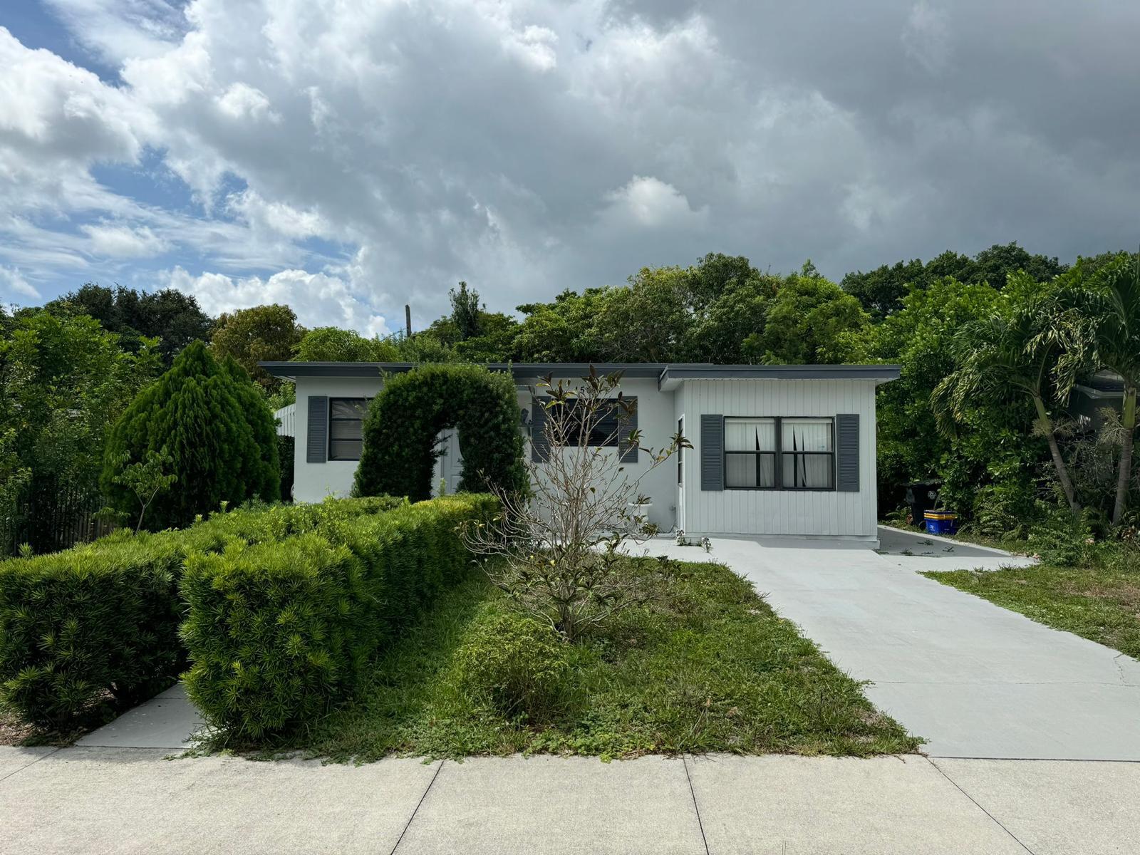 a front view of a house with a garden