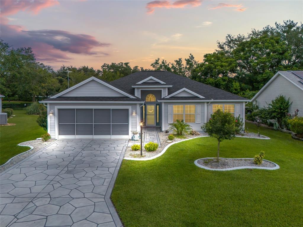 a front view of a house with a yard and trees