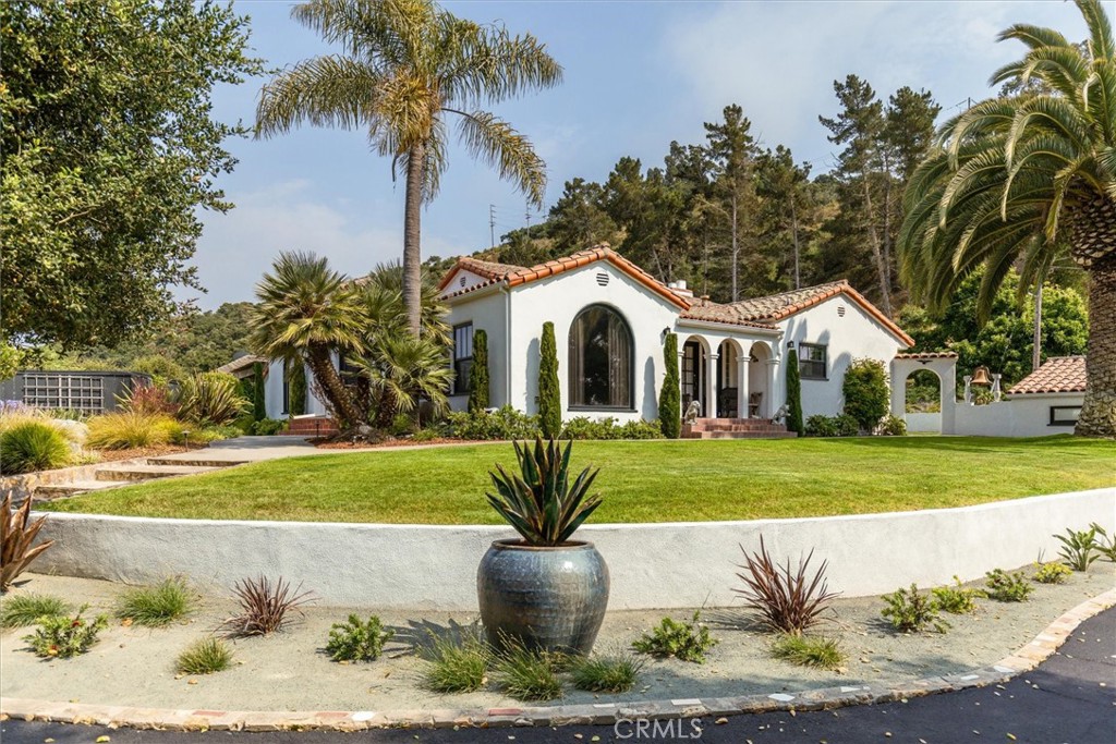 a front view of a house with a yard and trees