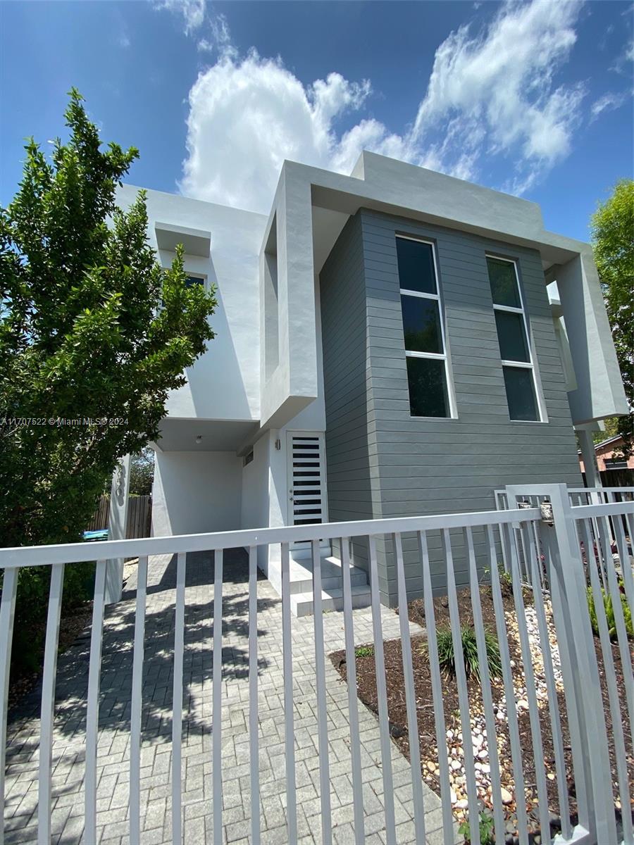 a front view of a house with plants