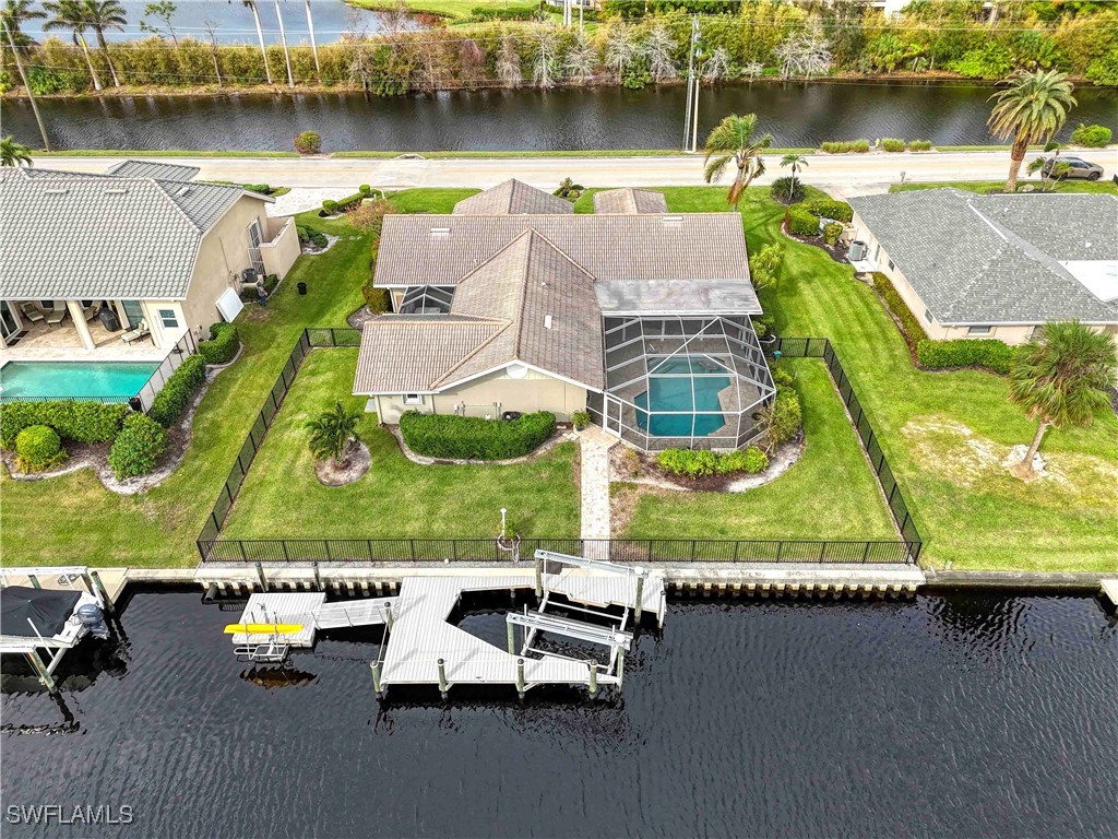 an aerial view of a swimming pool with outdoor seating and a lake view