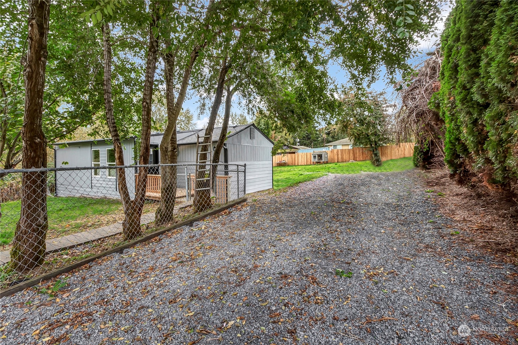 a view of a house with large trees and a small yard