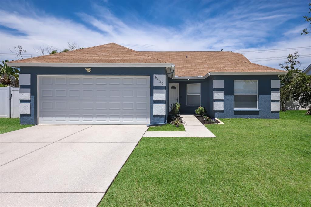 a view of a house with a yard and a garage