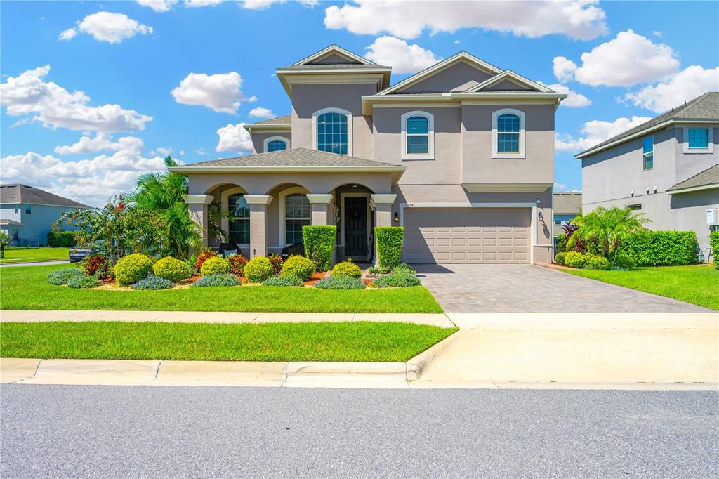 a front view of a house with a garden and yard