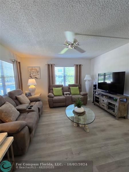 a living room with furniture a window and a flat screen tv