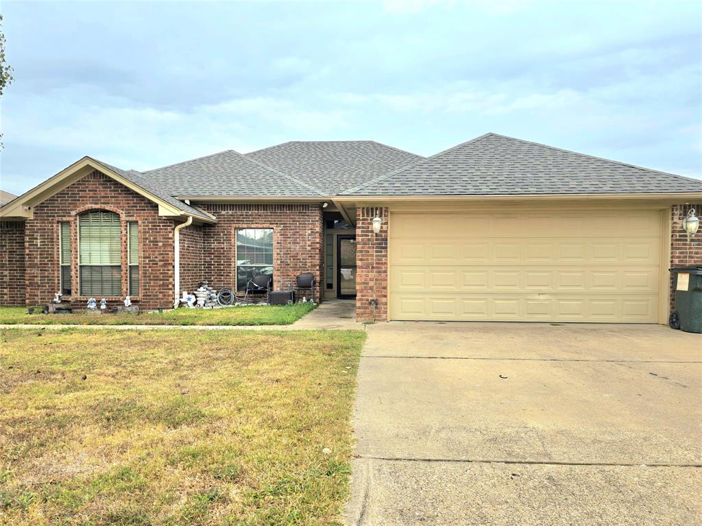 a front view of a house with a garden and yard