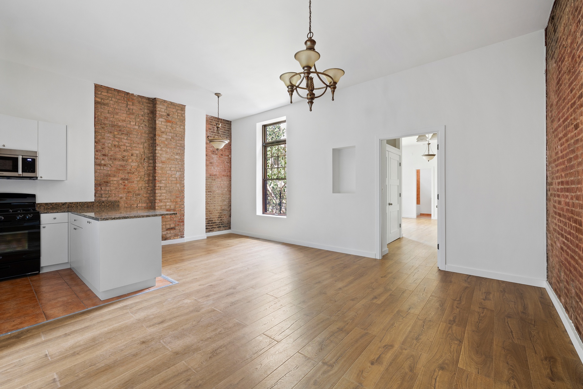 a view of a big room with wooden floor and windows