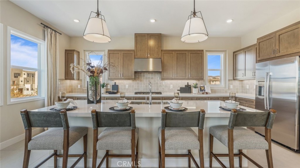 a kitchen with refrigerator a sink and chairs