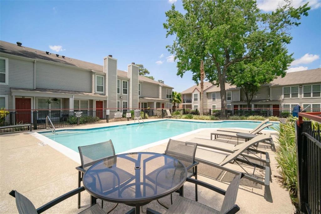 a view of house with swimming pool and outdoor seating