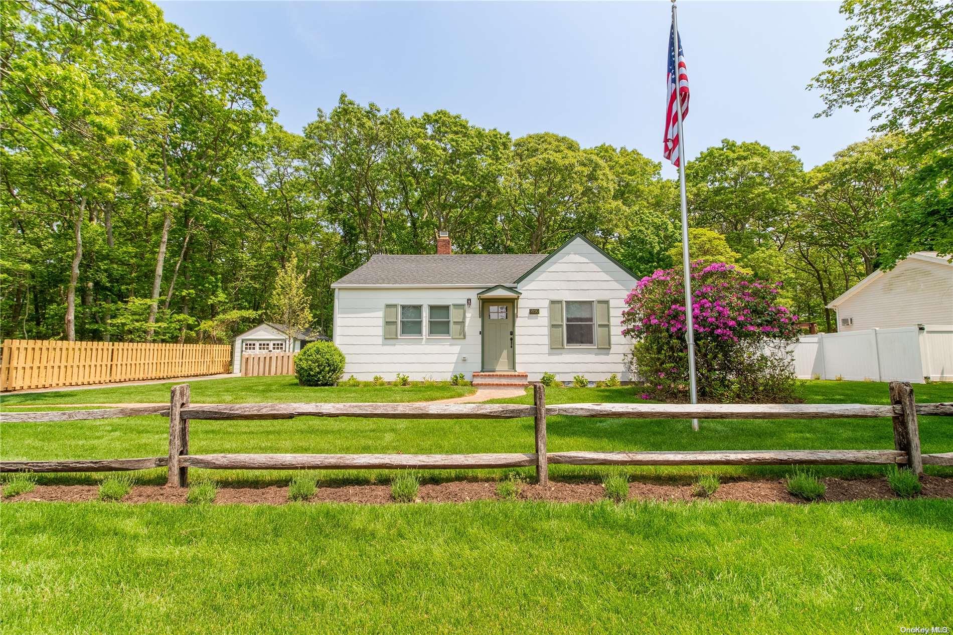 a front view of a house with a yard and trees