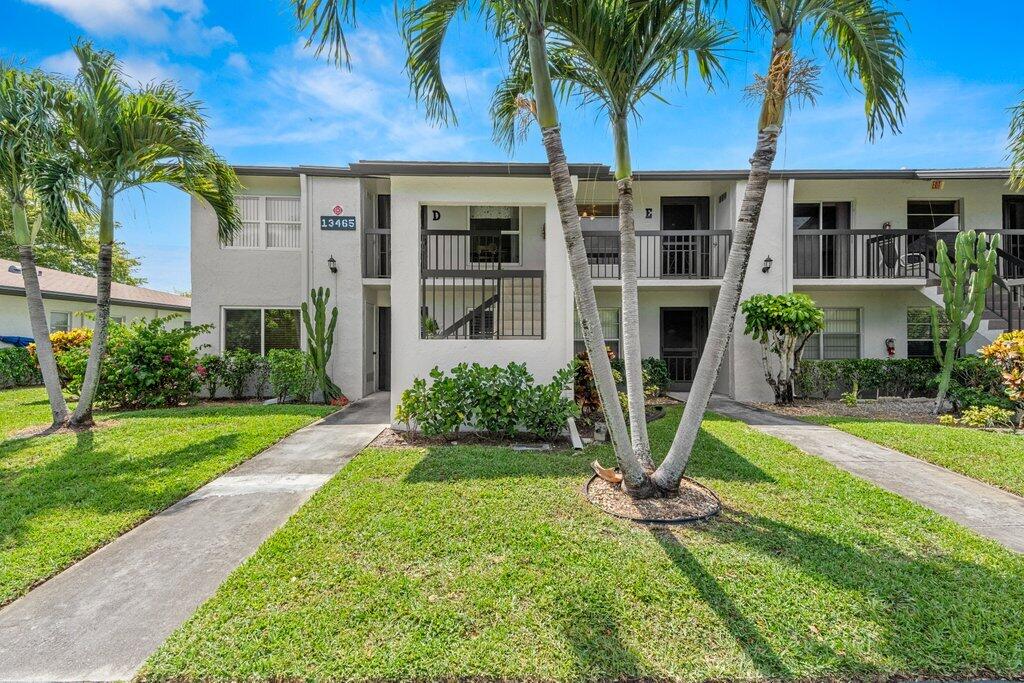 a view of a house with a yard and palm trees