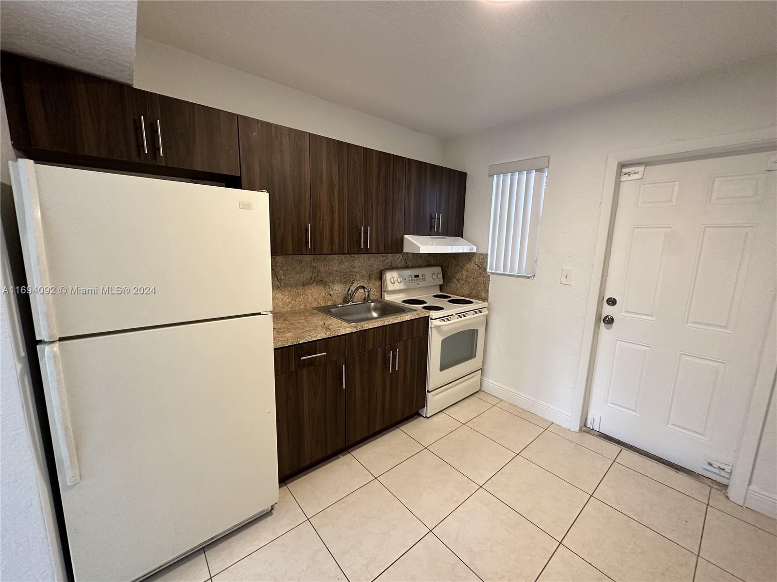 a white refrigerator freezer and a stove in a kitchen