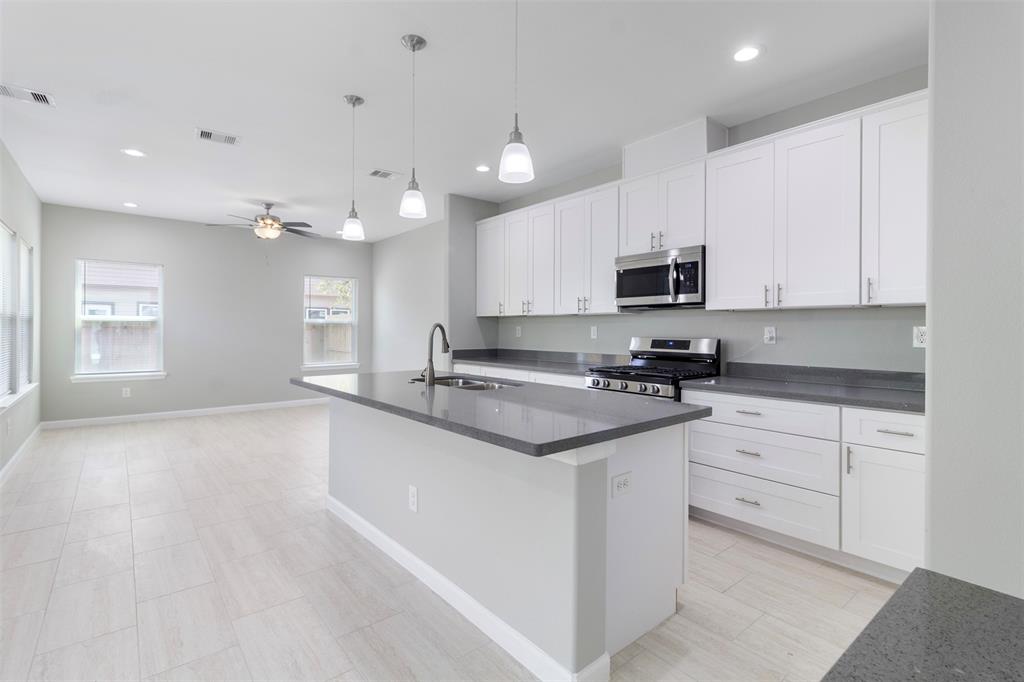 a kitchen with granite countertop white cabinets and white appliances