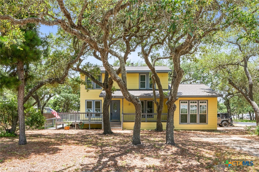 a front view of a house with a tree in front