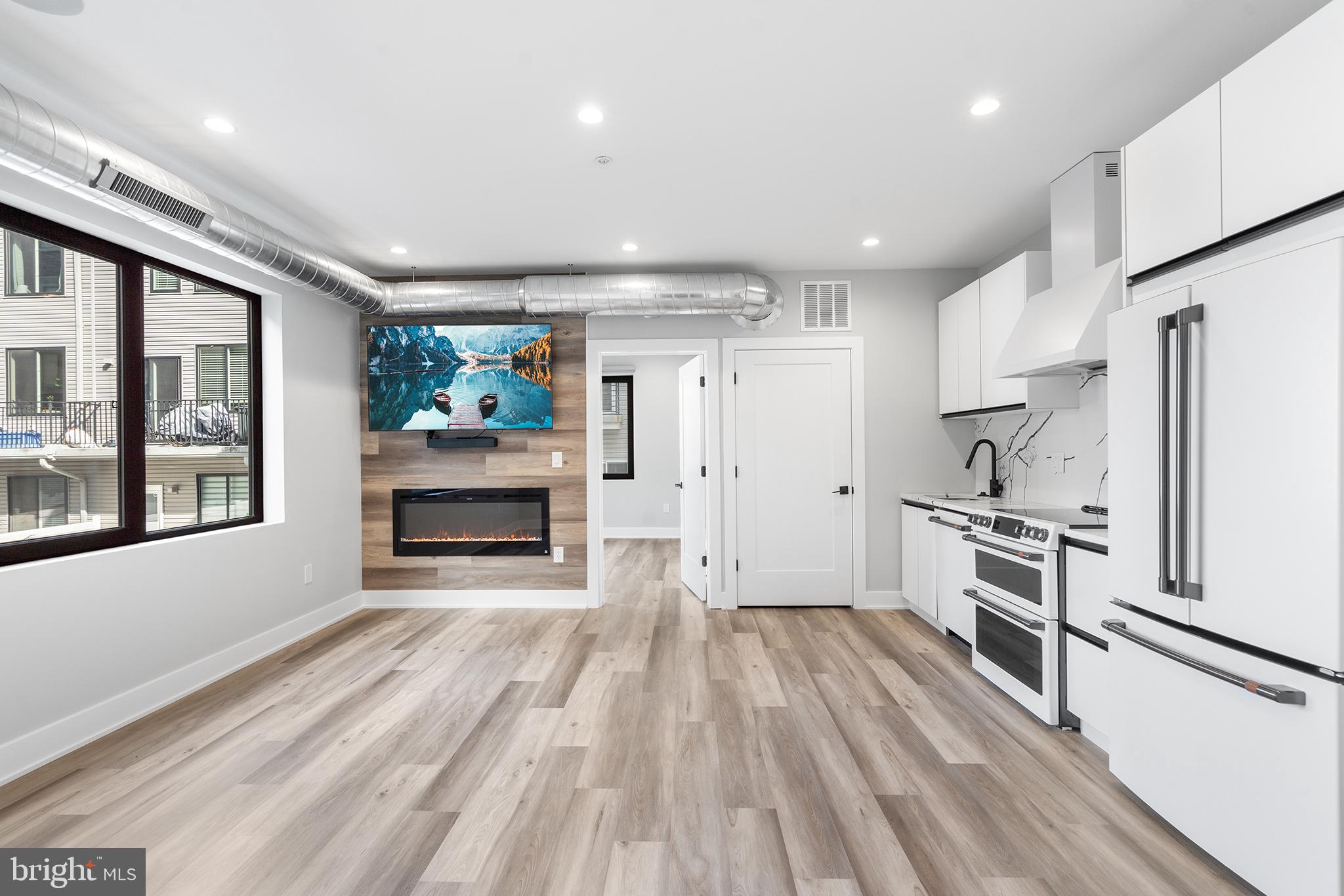 a kitchen with granite countertop kitchen island wooden floors stainless steel appliances and sink