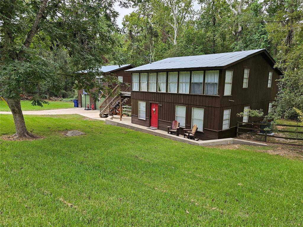 a view of an house with backyard and a tree