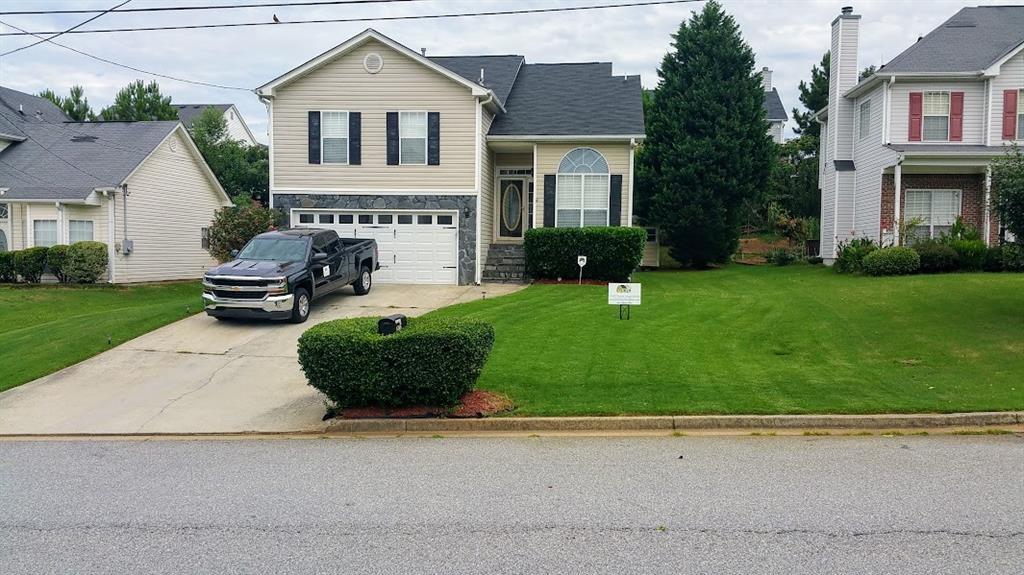 a front view of a house with a garden and yard