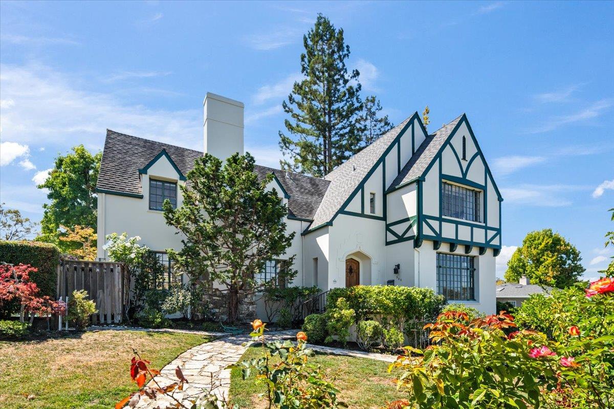 a view of a house with a yard and potted plants