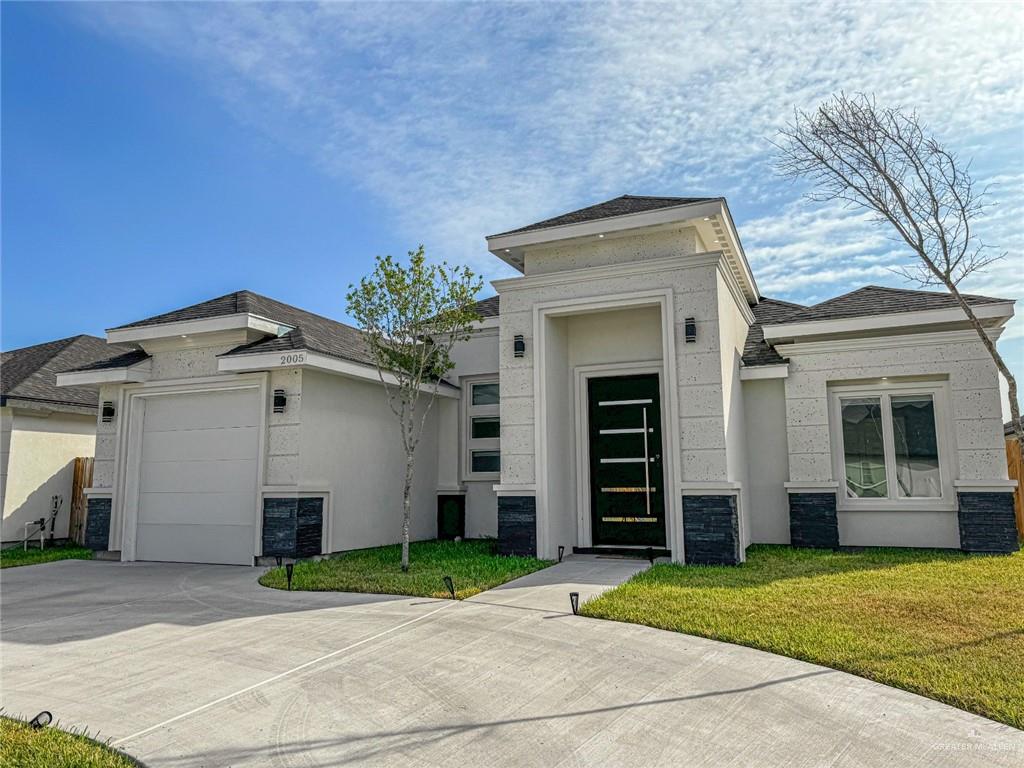 View of front of property featuring a garage and a front yard