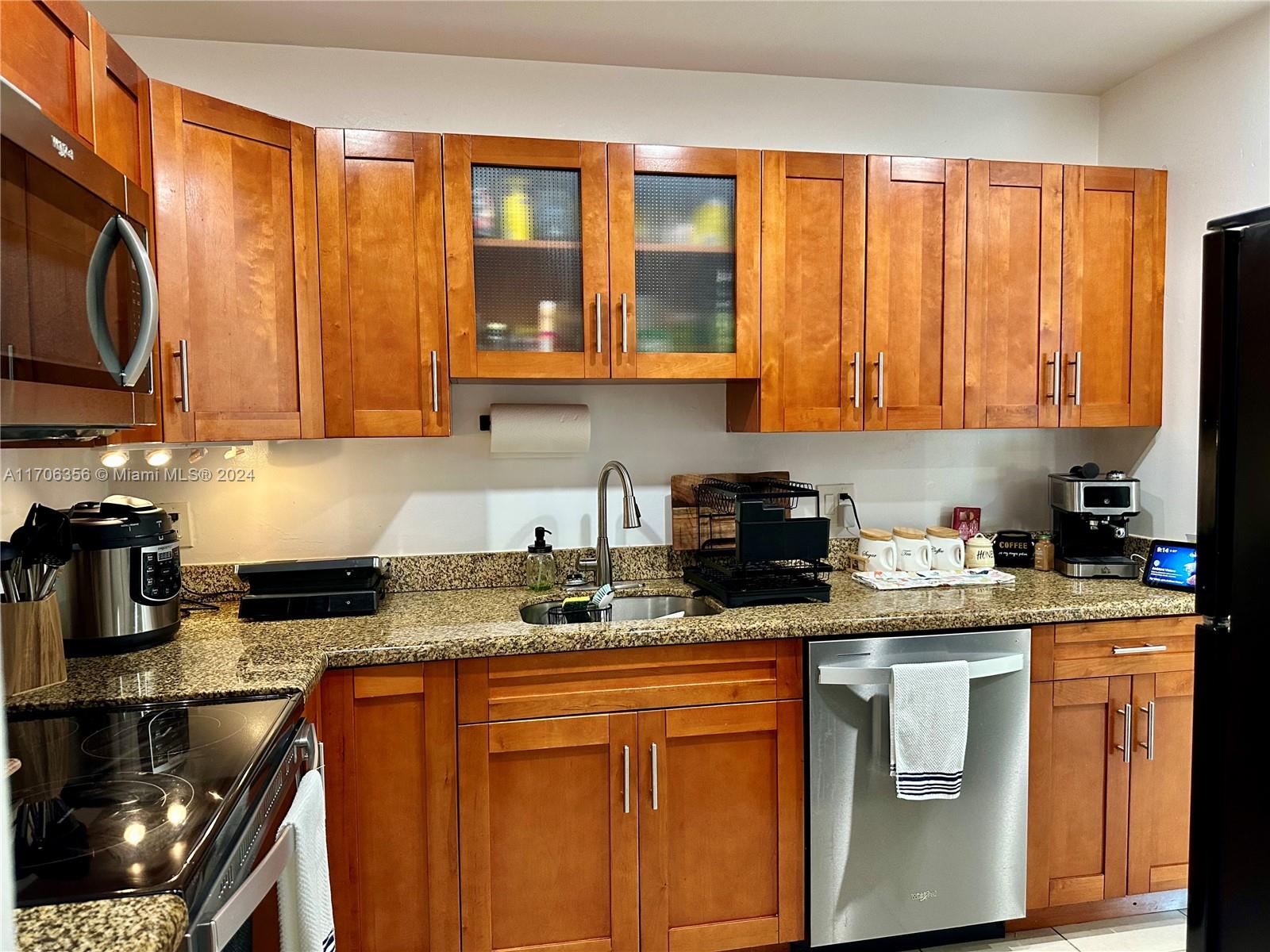 a kitchen with stainless steel appliances granite countertop a stove a sink and a microwave