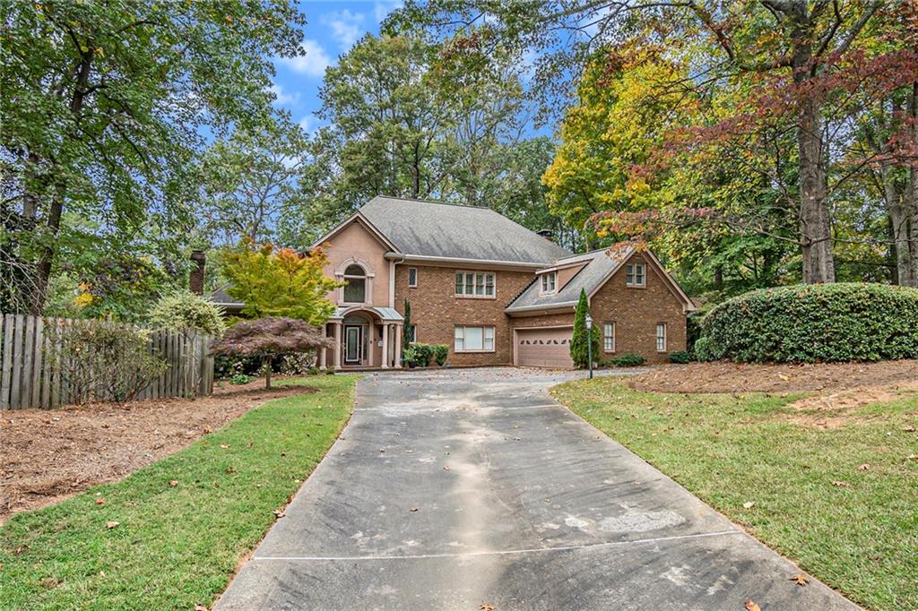 a front view of a house with yard and green space