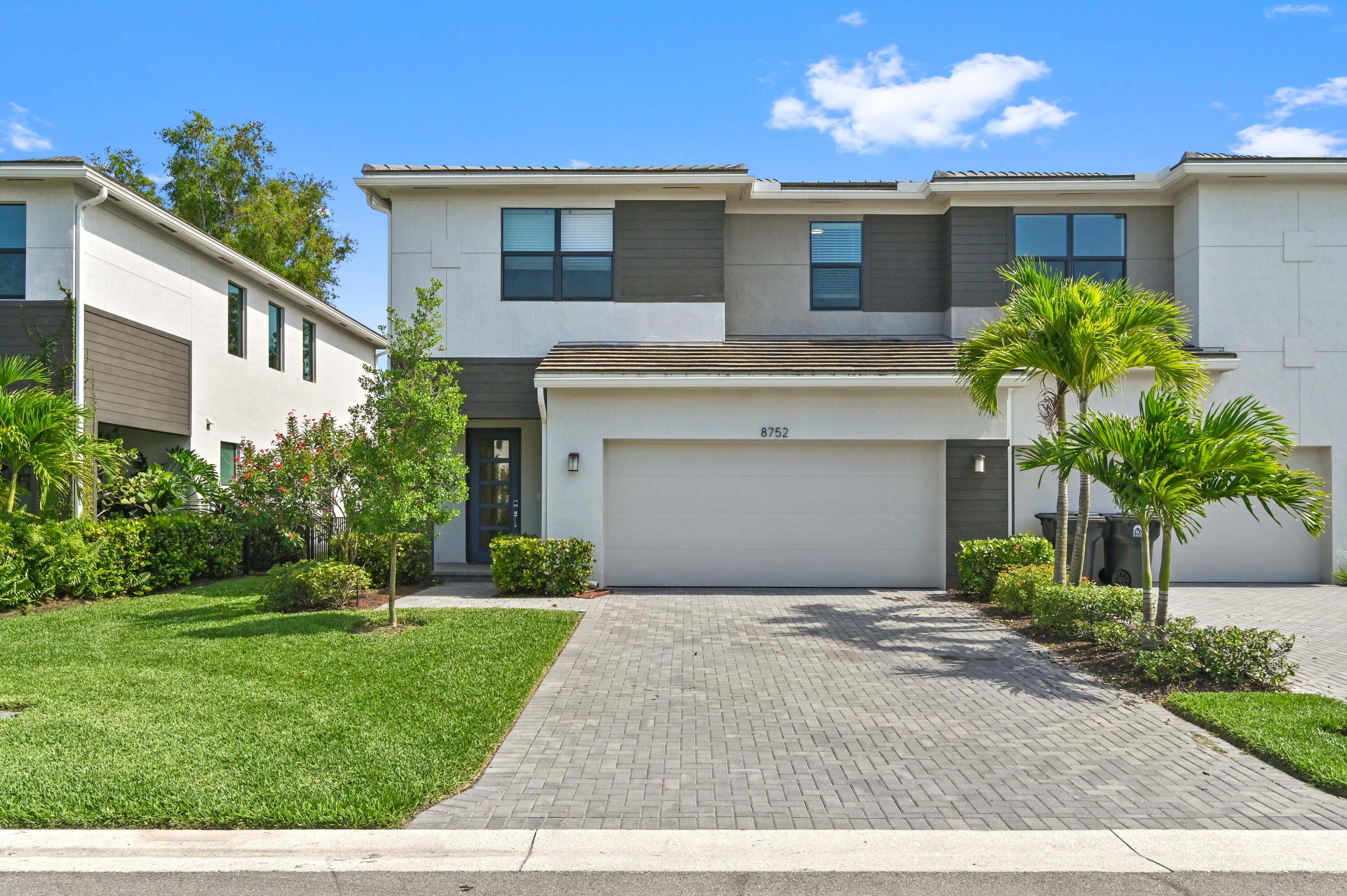 a front view of a house with a yard and a garage