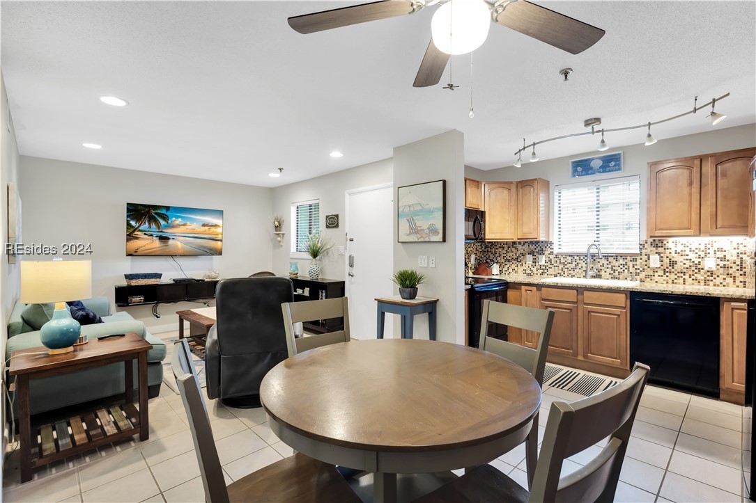 Dining space featuring ceiling fan, sink, and ligh