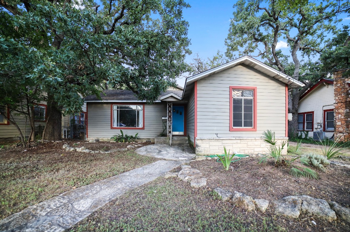 a view of a house with a yard and large tree