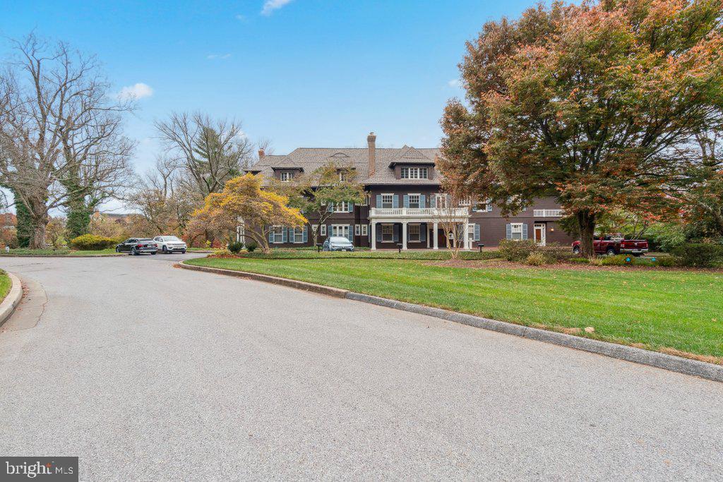 a view of a house with a big yard and large trees