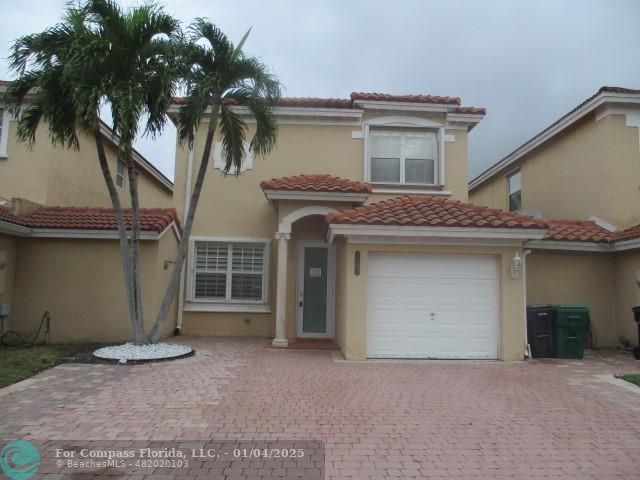 front view of a house with a yard and a garage