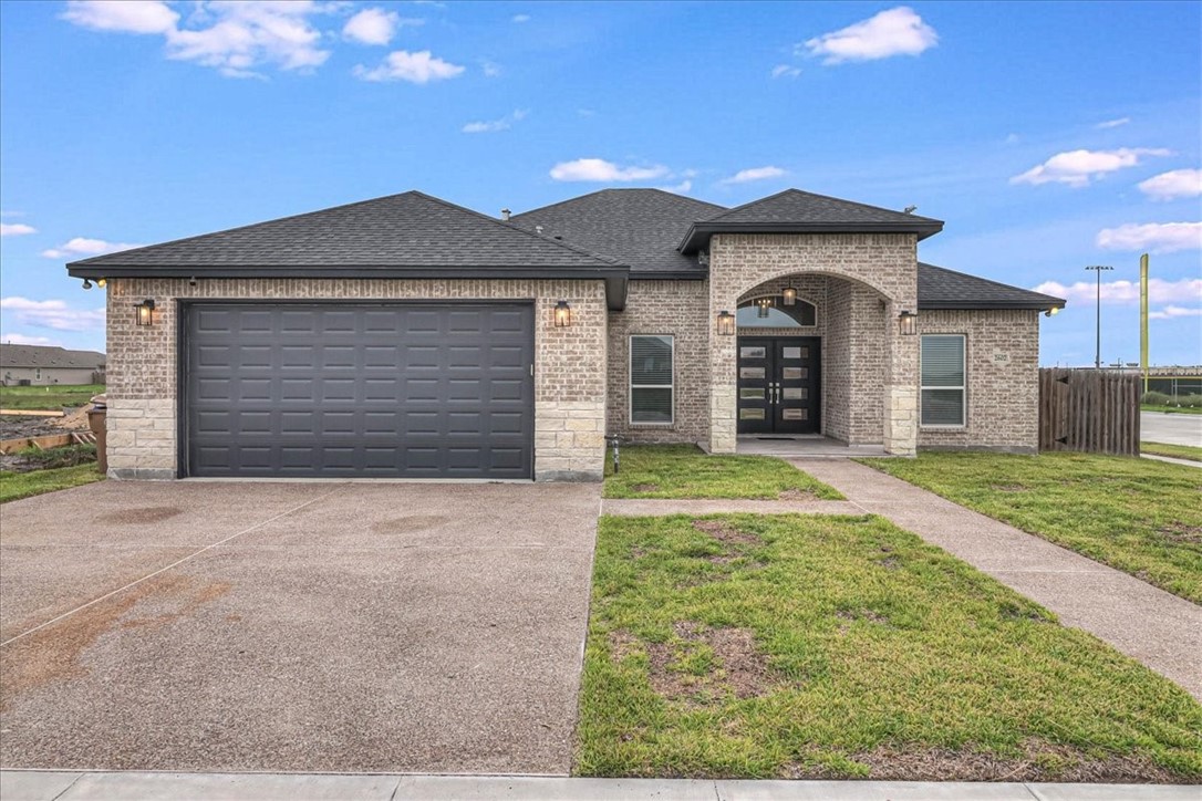 a front view of a house with a yard and garage