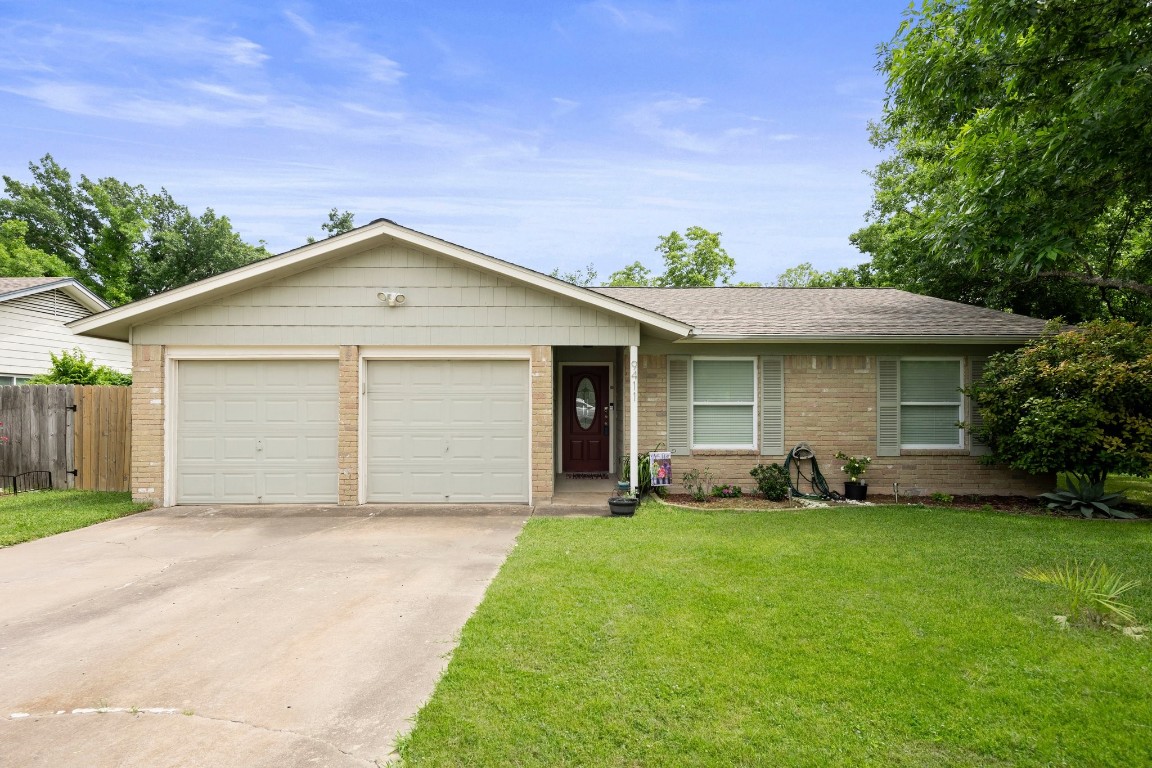 a front view of a house with a garden and yard