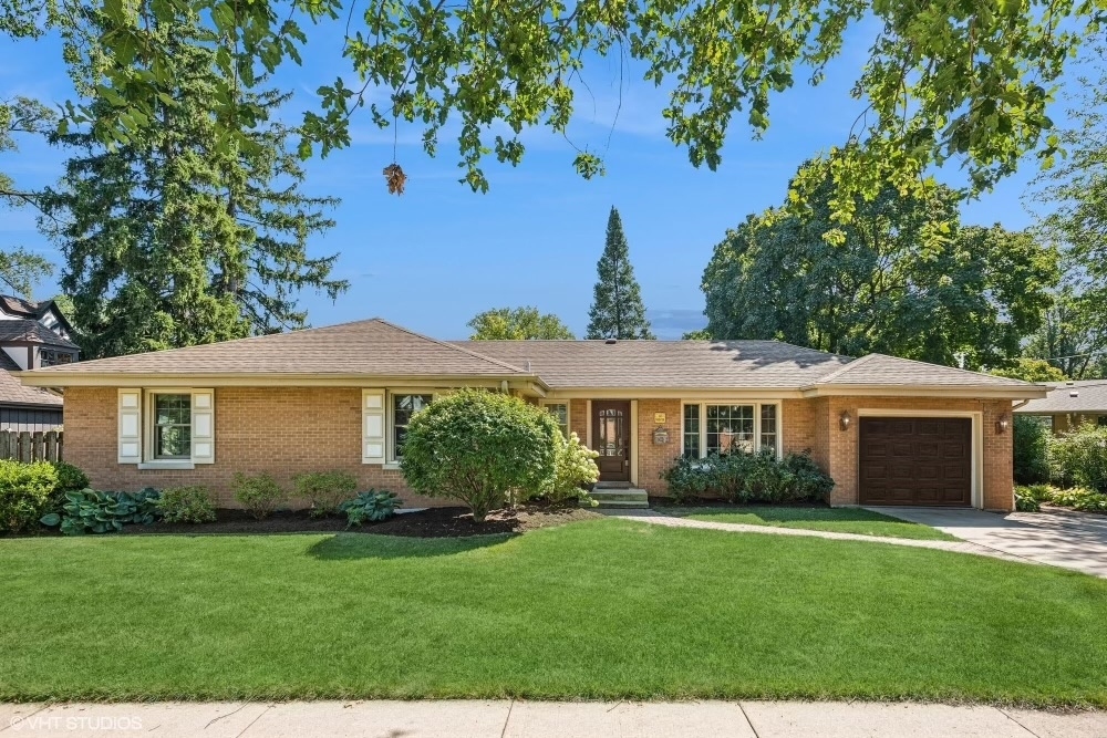 a front view of a house with a yard and potted plants