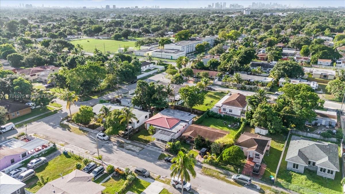 an aerial view of residential houses with outdoor space and trees