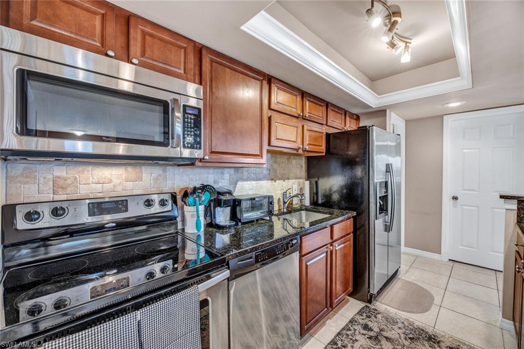 a kitchen with stainless steel appliances granite countertop a stove microwave and refrigerator