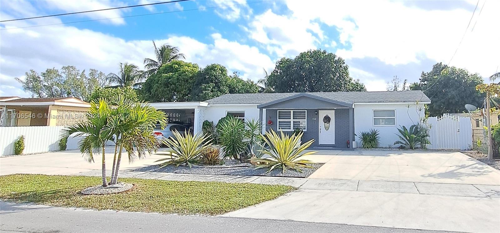 a front view of house with yard and trees around