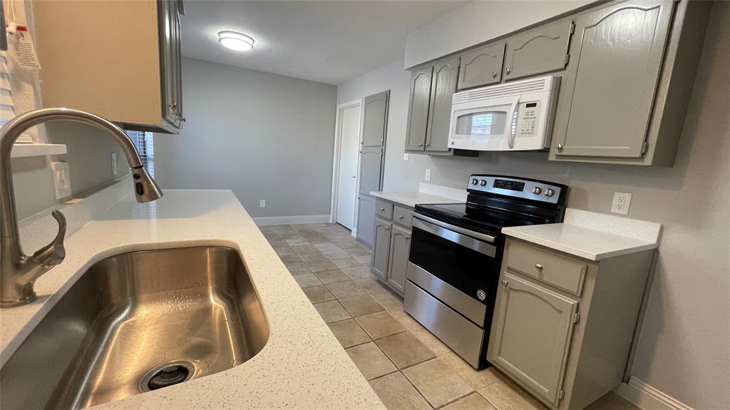 a kitchen with a sink and a stove top oven