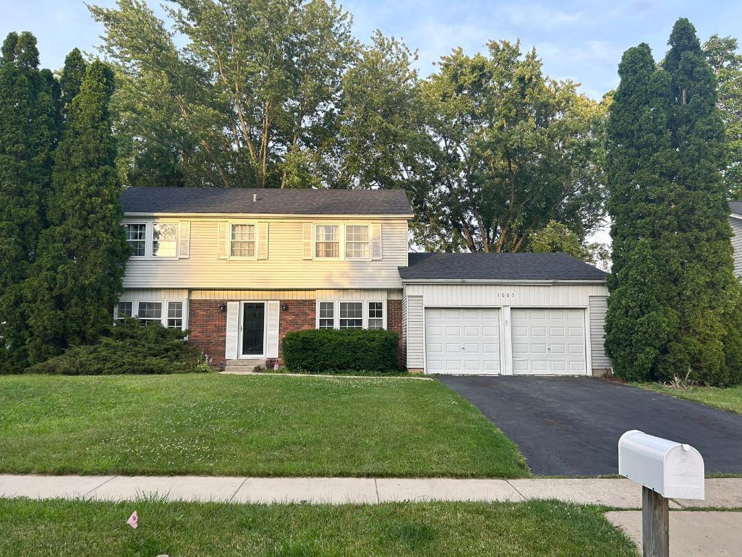 a front view of a house with a yard and trees