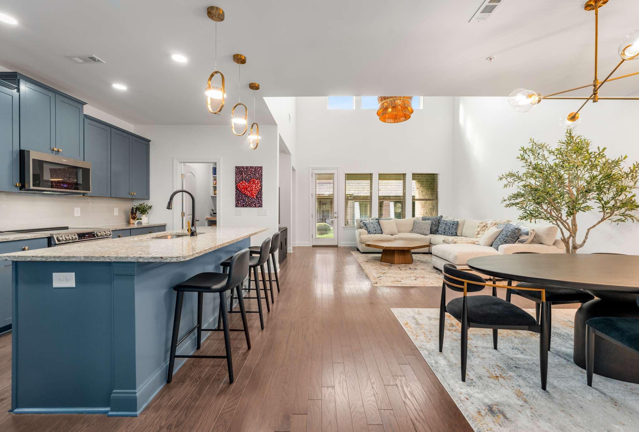 a kitchen with a sink a microwave a dining table and chairs