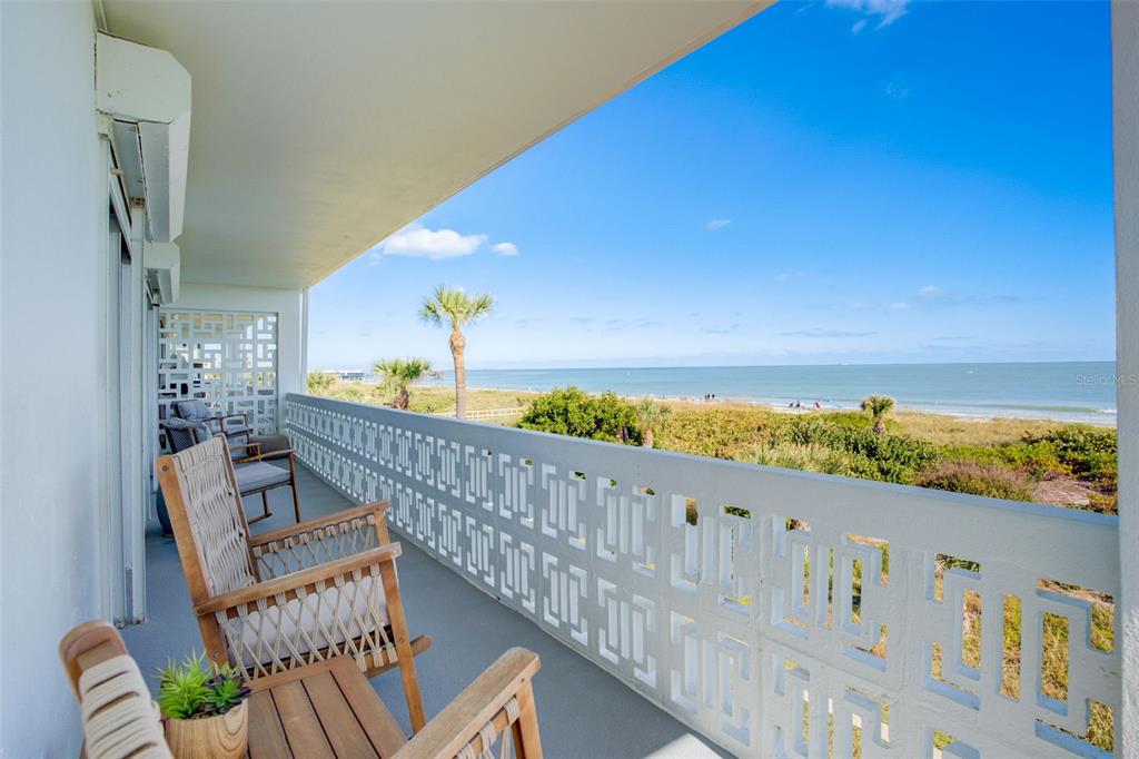 a view of a balcony with wooden furniture