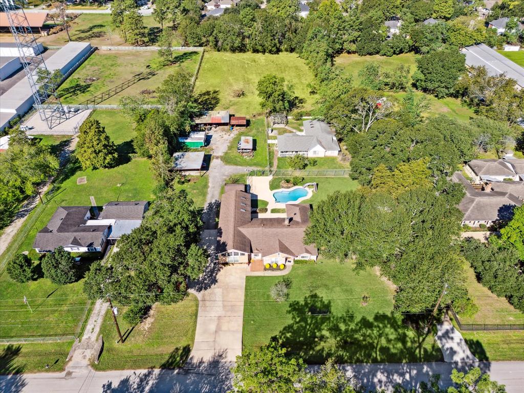 an aerial view of residential houses with outdoor space and trees