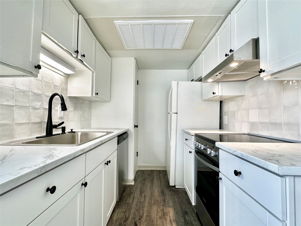 a kitchen with a sink cabinets and stainless steel appliances